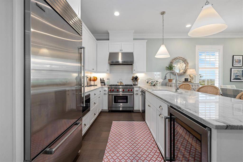 Kitchen features Sub-Zero & Wolf  appliances including a large built-in refrigerator and undercounter wine refrigerator.