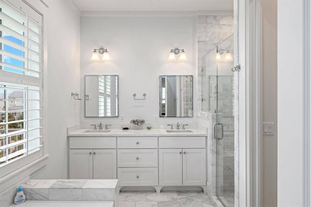 Primary Bathroom offers double vanity and marble tile throughout.