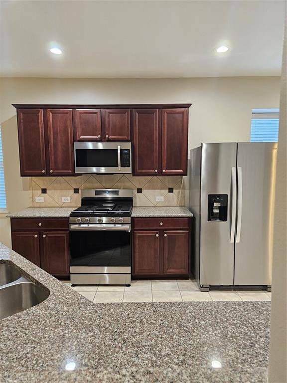 Kitchen with stainless steel appliances and granite countertops (refrigerator included).