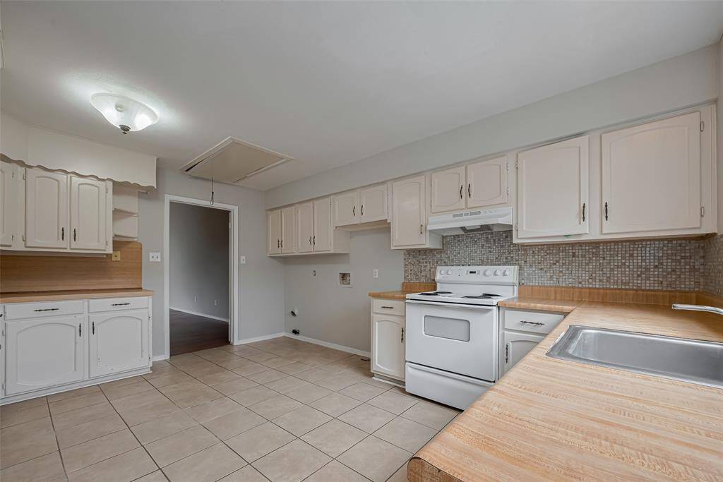 Spacious Kitchen With Ample StorageThis bright, open kitchen features abundant cabinet space, durable tile floors, and generous countertop prep areas—ideal for everyday meals or entertaining.