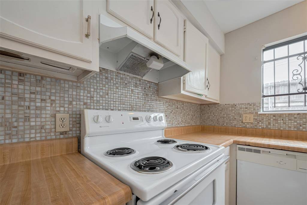 Classic Kitchen With Timeless FinishesFeaturing a clean electric cooktop, neutral mosaic backsplash, and abundant cabinetry, this kitchen blends functionality with charm for everyday ease.