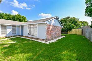 This is a single-story home with four sides brick. It features a spacious, well-maintained lawn and fully fenced, providing a sense of privacy. The large windows allow for ample natural light.