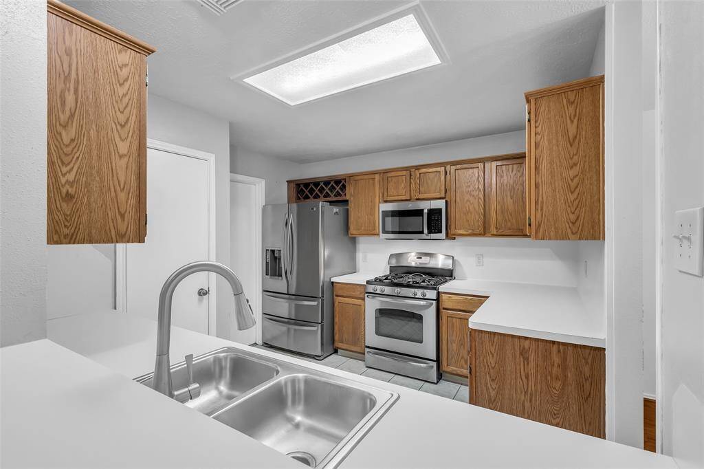 The kitchen has many popular features including a Double Stainless Steel Sink, Stainless Water Fixture with Water Wand, Stainless Refrigerator (included in the purchase), Stainless Microwave, Stainless Gas Stove/Oven and tile flooring.