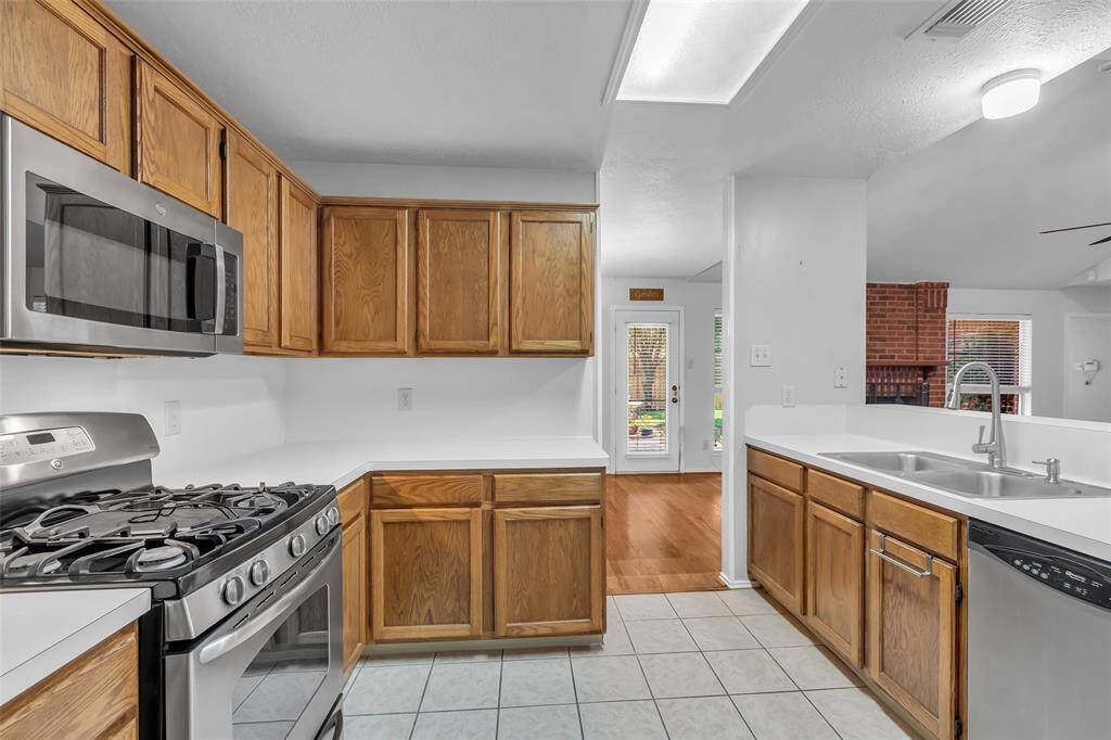View of Kitchen pass through to Breakfast/Dining Room.  The wrap around counters and wood cabinet provide great space for preparing favorite meals and storing all your kitchen implements.  The Kitchen has an open view to the Family Room.