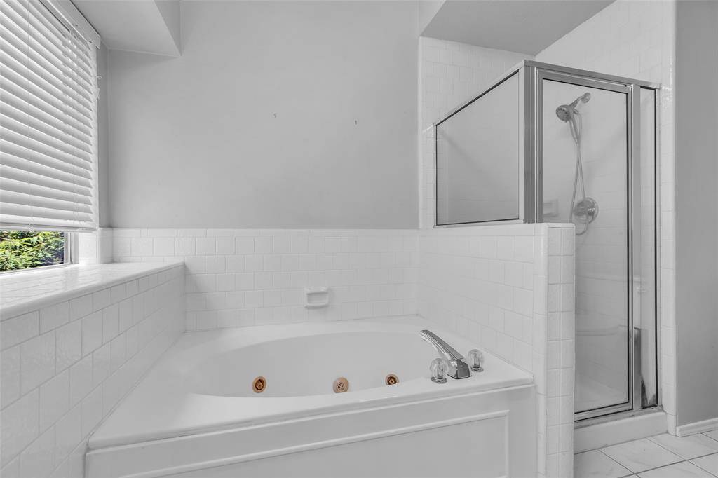 Large Jetted Tub and Separate Shower with shower water wand.  The bathroom features tile flooring through out.