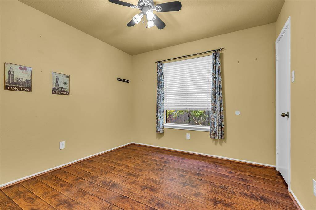 Bedroom 3 features engineered wood flooring, ceiling fan with lighting and large closet.