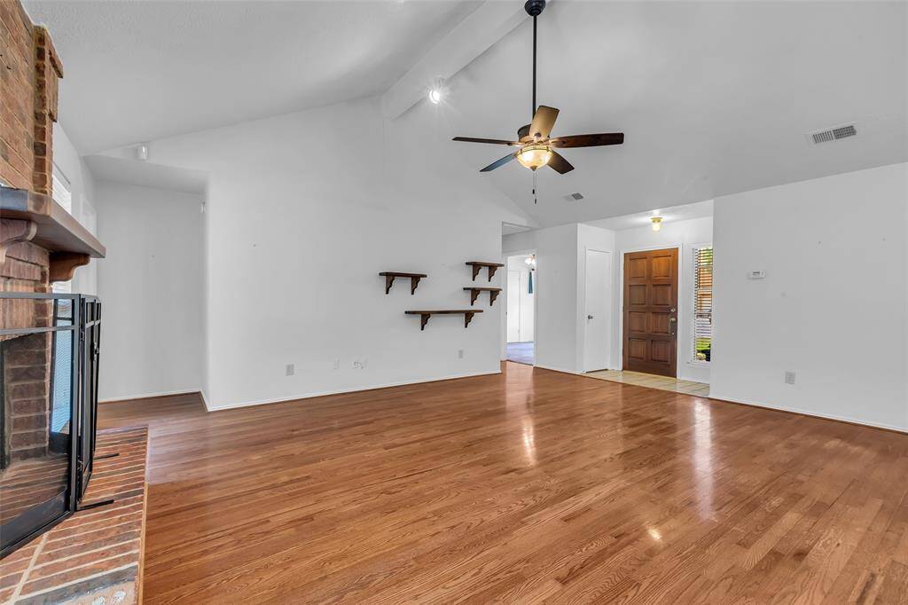 This view of the Family room shows, the brick hearth fireplace, tiled floor entry and coat closet.