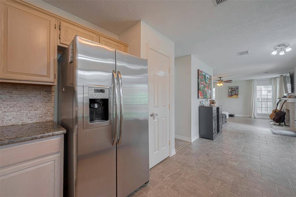 Modern kitchen with stainless steel appliances opens to a bright, spacious living area. Ideal for entertaining and comfortable living.