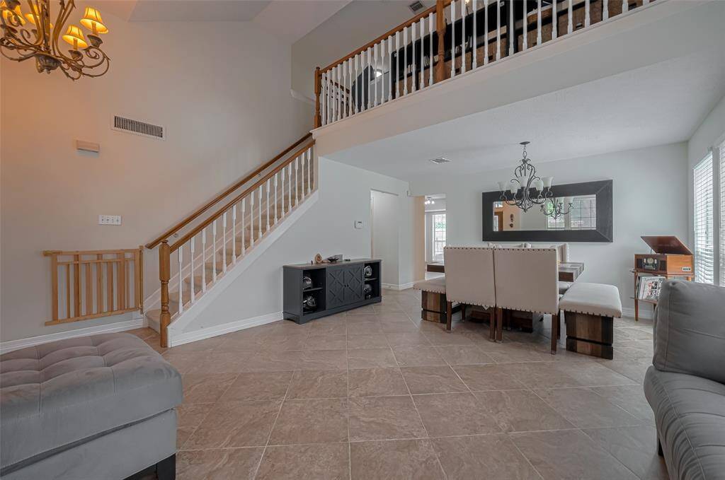 Spacious and well lit Primary Bedroom with plenty of room for a large bed and a private sitting area. Neutral walls and soft carpeted flooring.