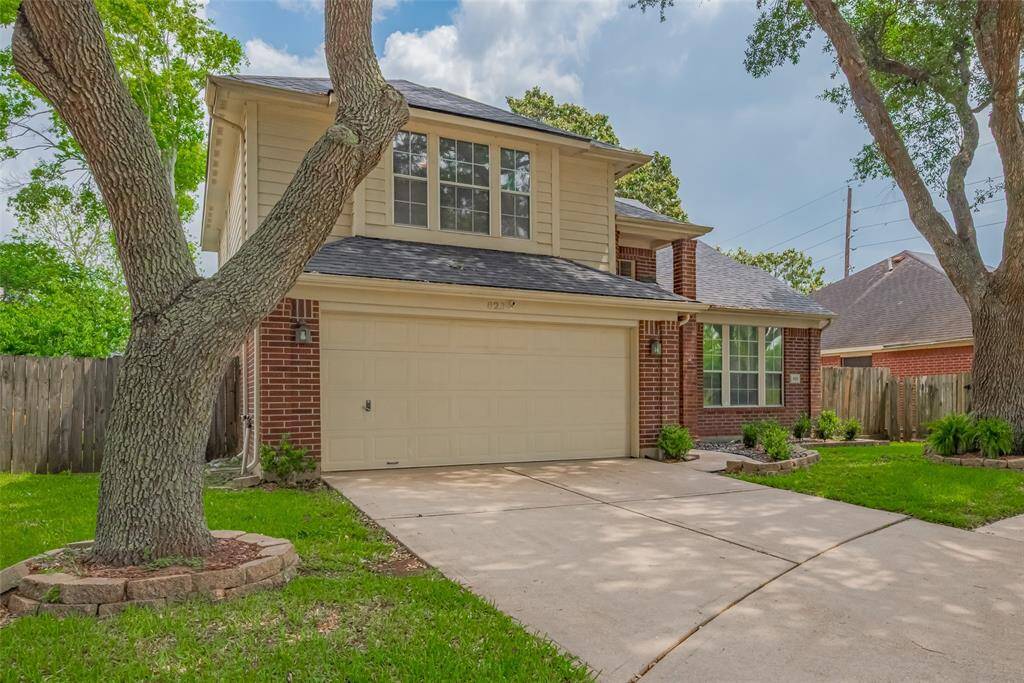 Lovely two-story brick home with mature trees, a wide driveway, and a private fenced backyard in a peaceful, family-friendly neighborhood