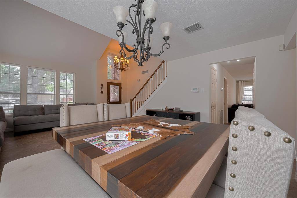 This inviting living space features high ceilings with elegant matching chandeliers in the entry way and Formal Dining Room with ample natural light from the large windows.