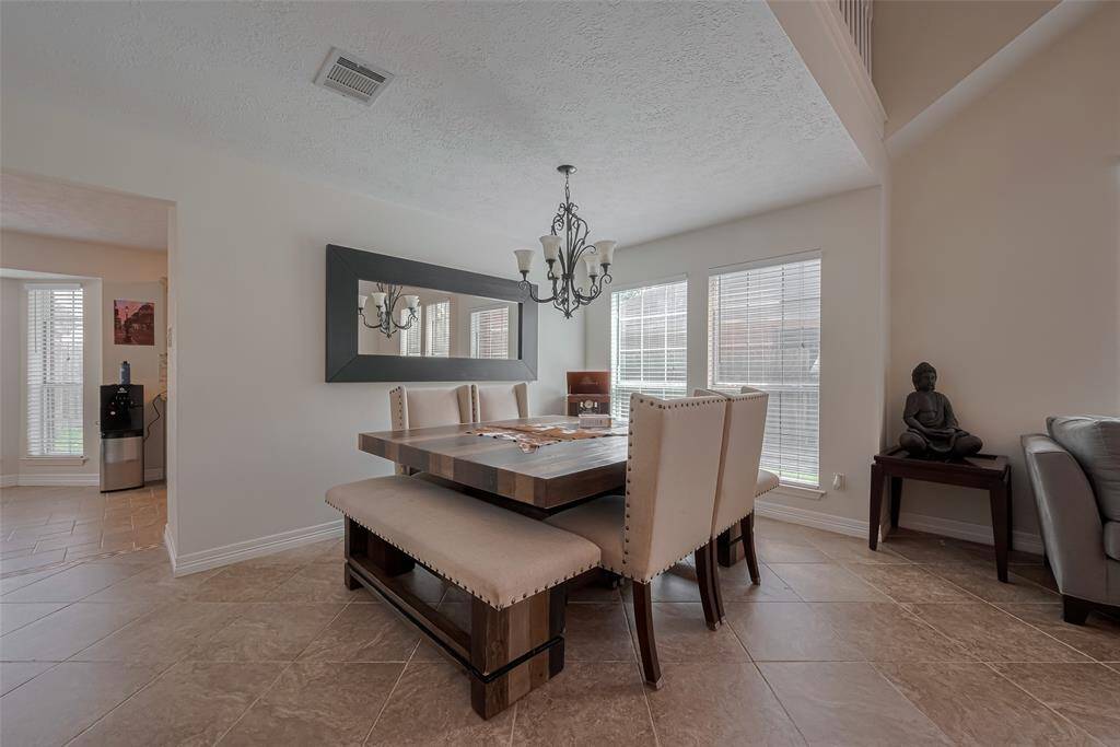 Welcome to your new home! This elegant dining area features abundant natural light, a stylish chandelier, and ample seating for gatherings. Perfect for entertaining and creating lasting memories.