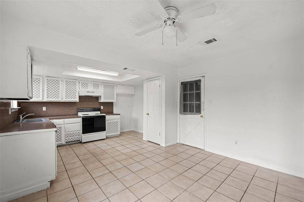 A large, spacious kitchen has plenty of cabinets for storage and a pantry as well.