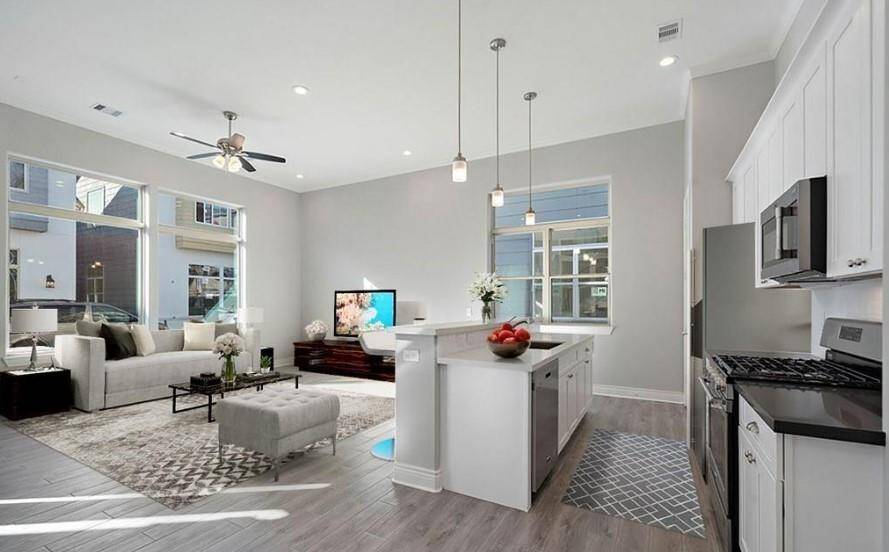 *Virtually Staged* A view of the living room and kitchen from the dining room.