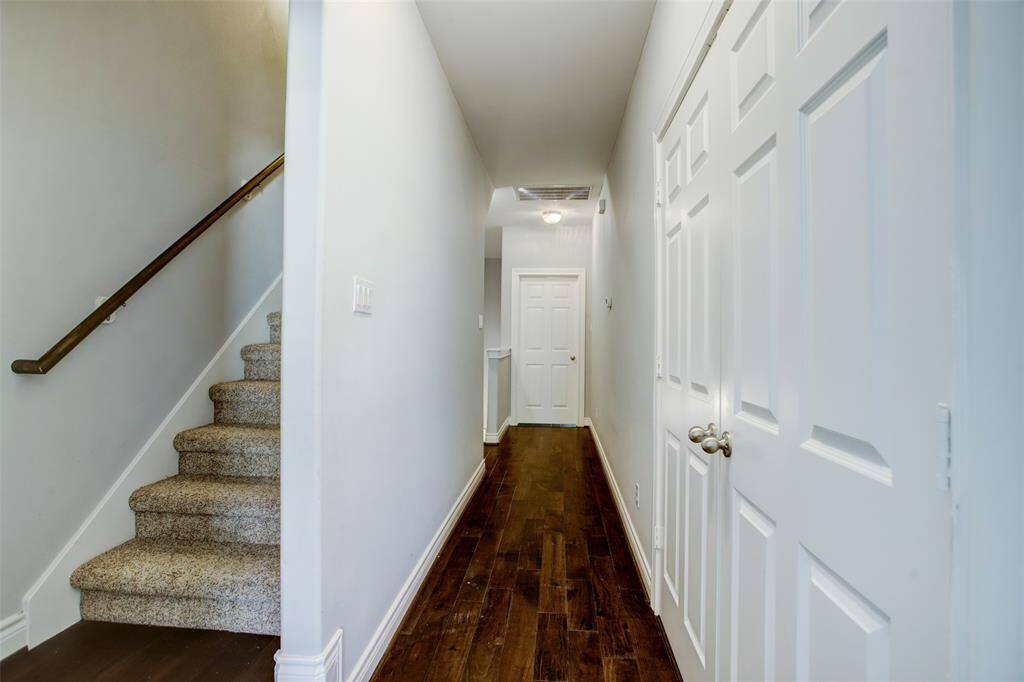 View of the hallway from the primary suite to the 2nd floor ensuite guest bedroom.  The double doors open to the homes laundry room area.