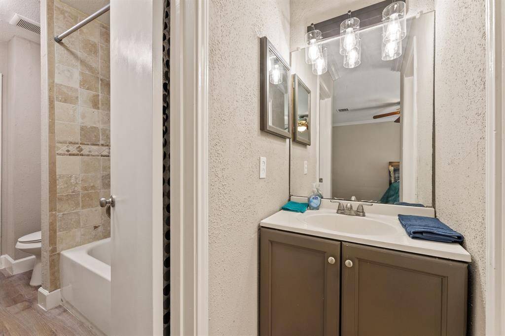 Small vanity is next to shared bathroom
