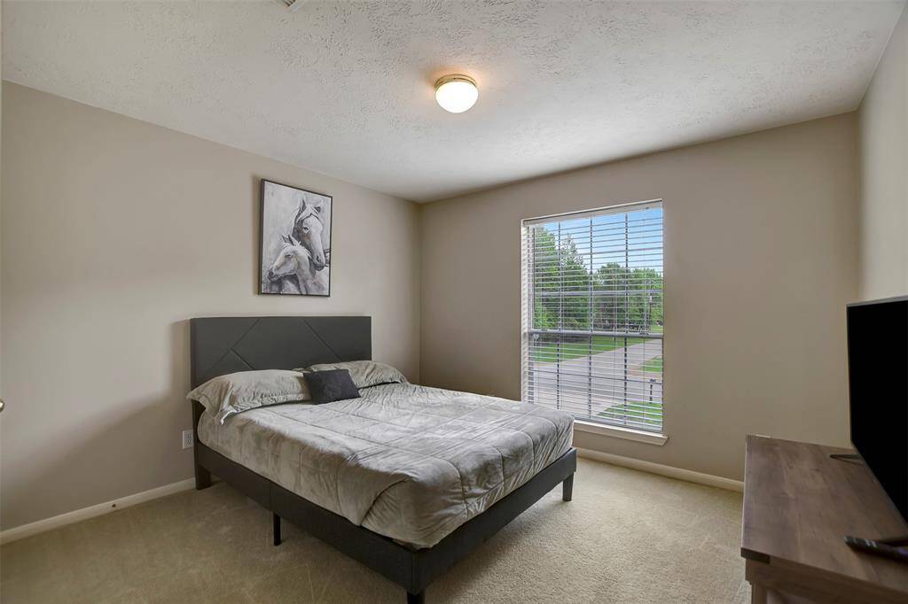The third secondary bedroom is spacious with a large window.