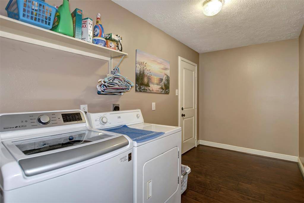 Spacious laundry room (13.10x6.6) with a shelf for storage. It features a door to the backyard, perfect area for kids toys, etc. Lots of possibilities!