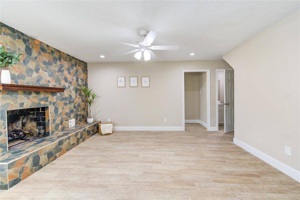 Another view of the open living space. This living area offers comfort and relaxation where you can imagine your furniture in a variety of configurations.  A doorway leads to the half bath and primary suite, enhancing the space's functionality.