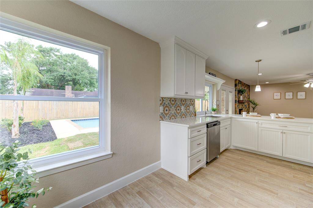 Large new window offers a view of the backyard with a pool and lush greenery. Open layout with plenty of natural light and a cozy dining area.