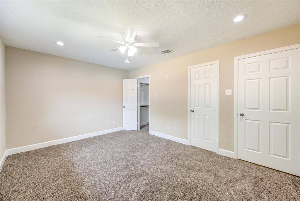 Another view of the primary suite - doors leads to primary bath and custom built walk-in closet.