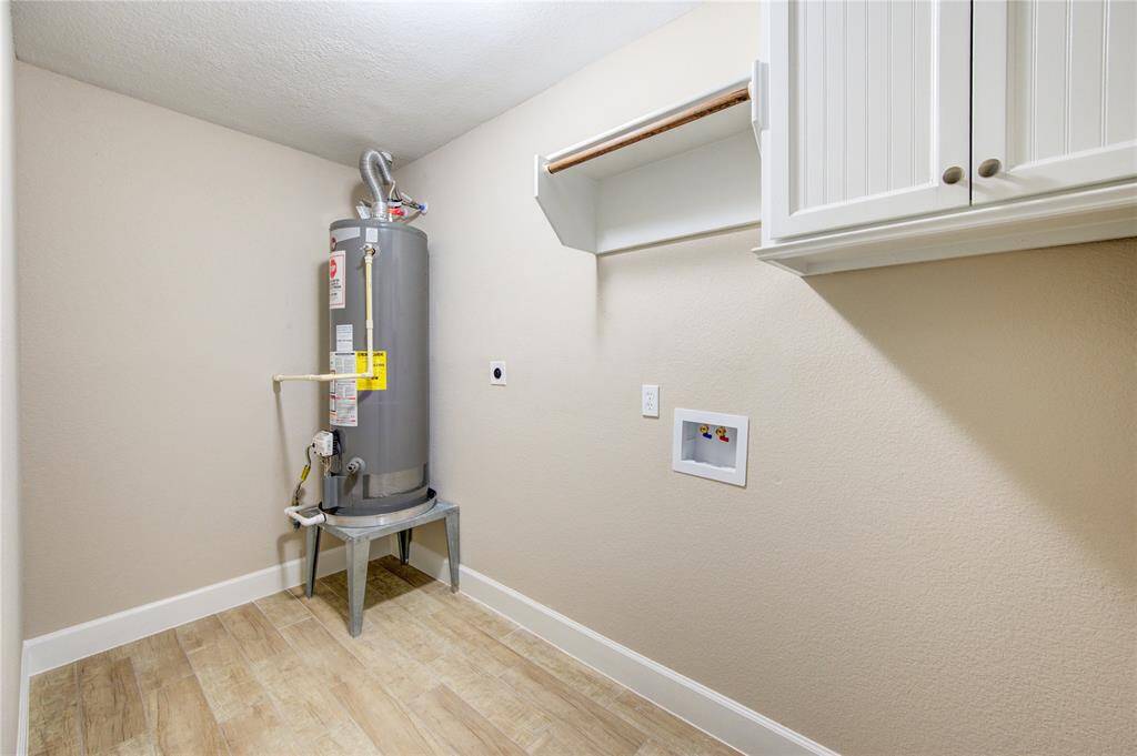 A nice sized utility room located downstairs, is ready to hold a full sized washer and dryer, store detergents and hang some clothes. , and a shelf for additional storage.