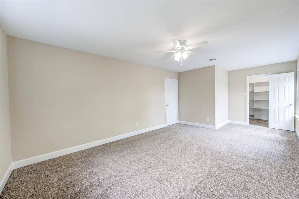 Another view of bedroom #3. It includes a walk-in closet with built-in shelving, ideal for storage.