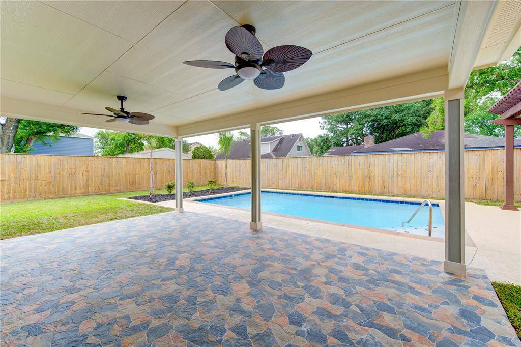 This is another view from the covered patio overlooking the gorgeous swimming pool, offering a perfect space for relaxation and outdoor entertaining.