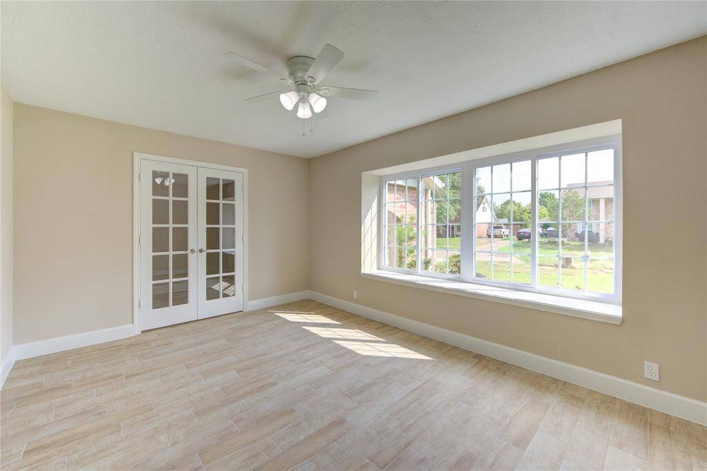 Another view of the flex room. Bright room with large windows and French doors add elegance and natural light fills the space, creating a welcoming atmosphere.
