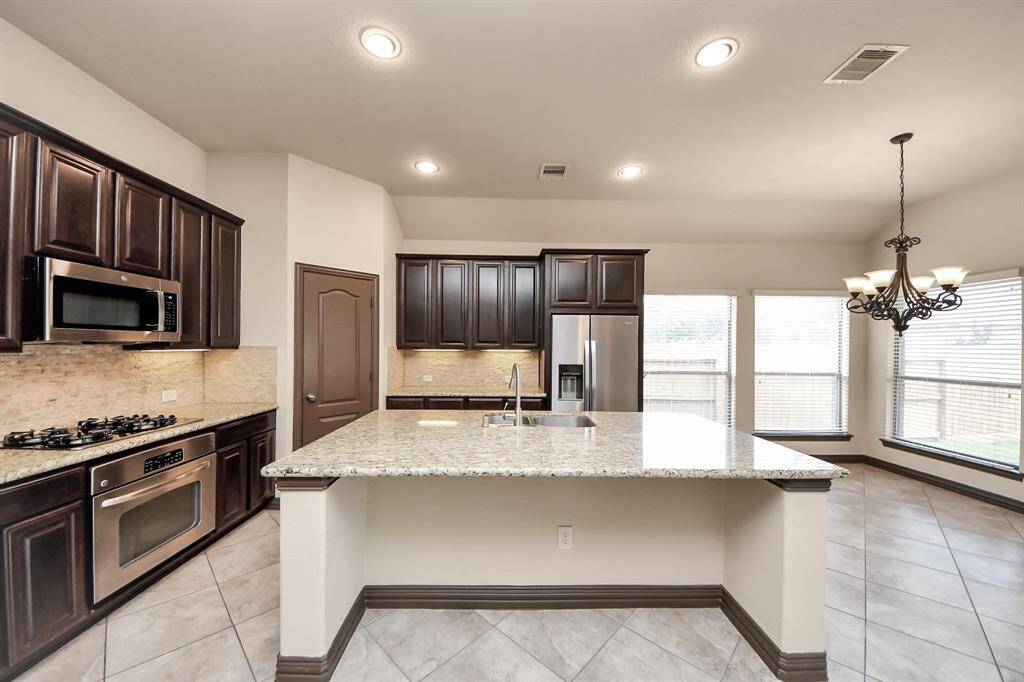 The oversized kitchen island doubles as a prep space and casual gathering spot.