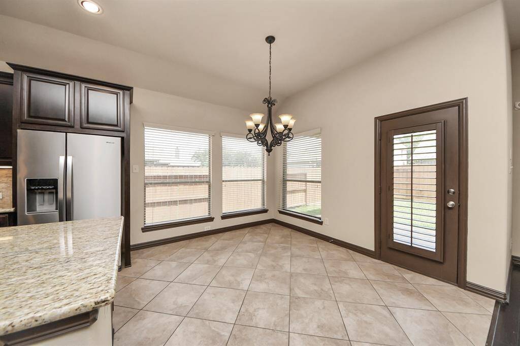 Enjoy meals with backyard views in this sunlit breakfast nook.