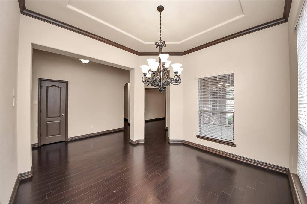 Dine in style beneath a stunning chandelier in this bright and spacious formal dining room.