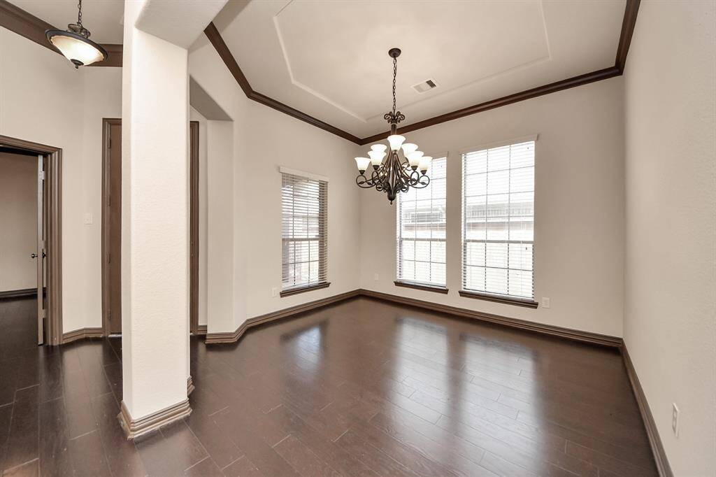 Natural light floods the space through tall windows, creating a perfect setting for meals and memories.