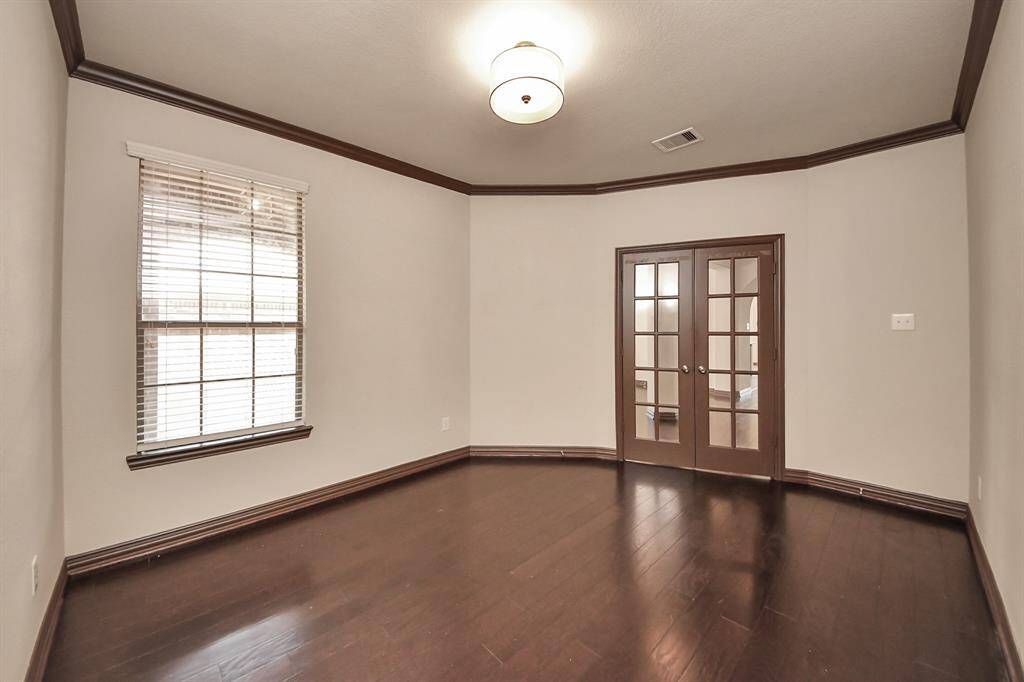 French doors open to a flexible room ideal for a home office, playroom, or cozy sitting area.