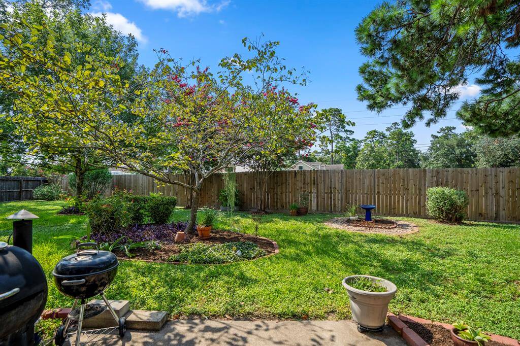 Spacious backyard features wooden privacy fence and concrete patio