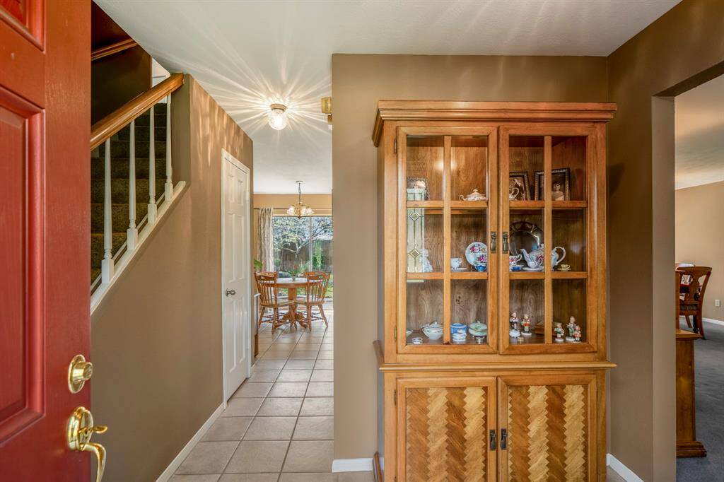 This is an inviting interior hallway leading to a well-lit breakfast area with a view of the backyard