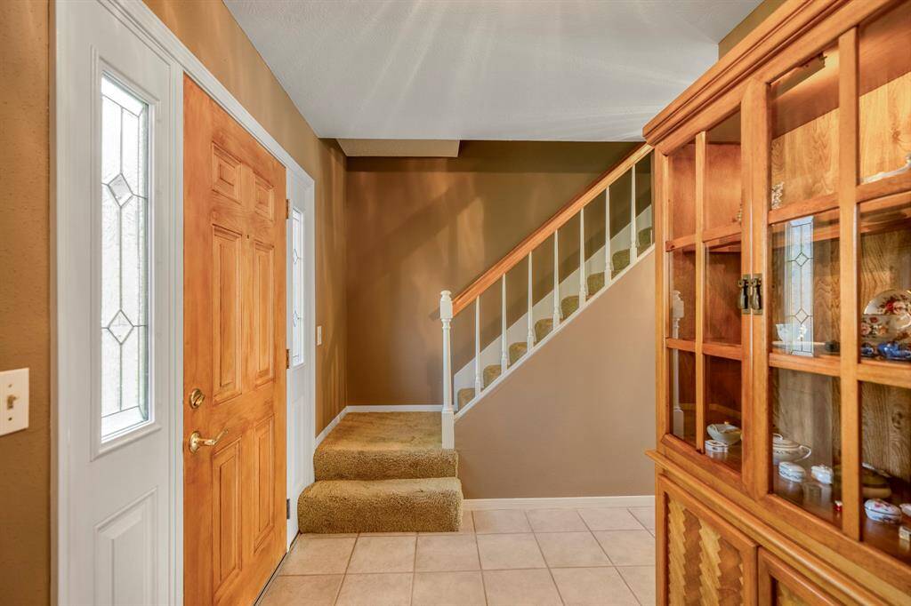 This cozy entryway features a warm-toned wooden front door.
