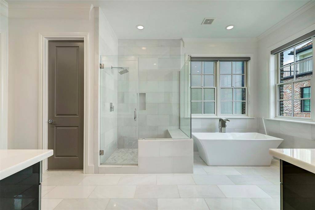 Primary Bathroom with its separate soaking tub and shower with bench seating and separate vanities too! The private water closing is behind the closed door.