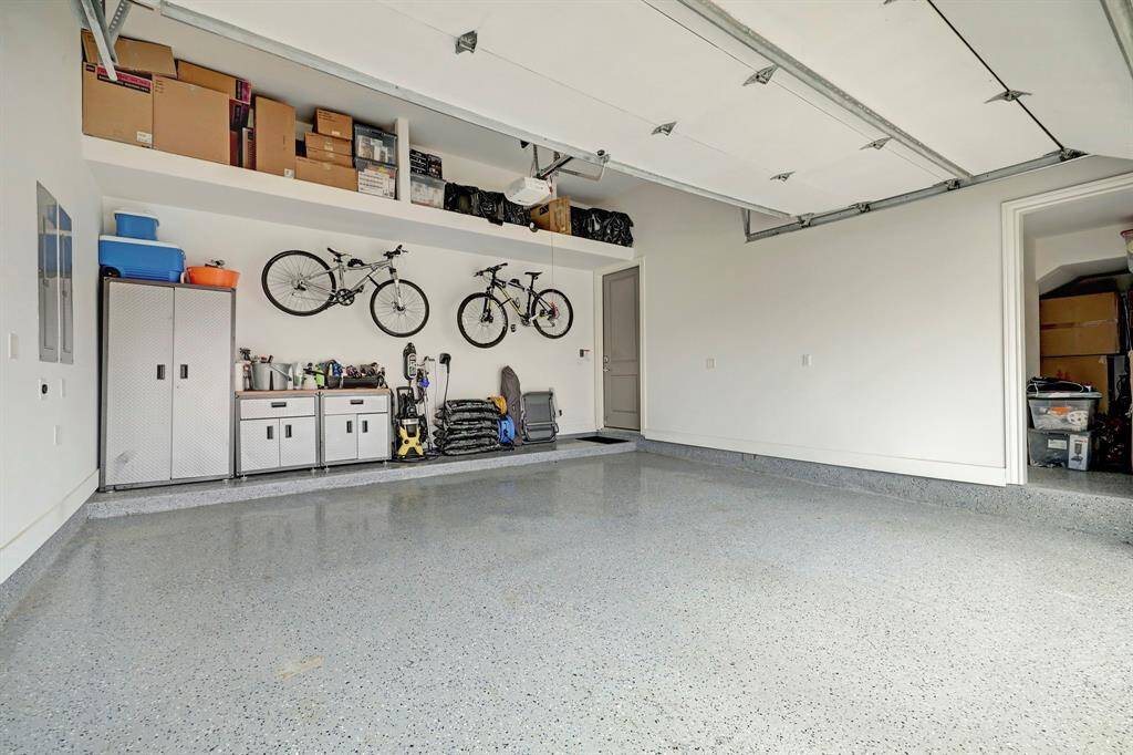Garage is epoxy-coated and has lots of extra storage. Built in shelves overhead and see the opening on the right is an accesible storage.