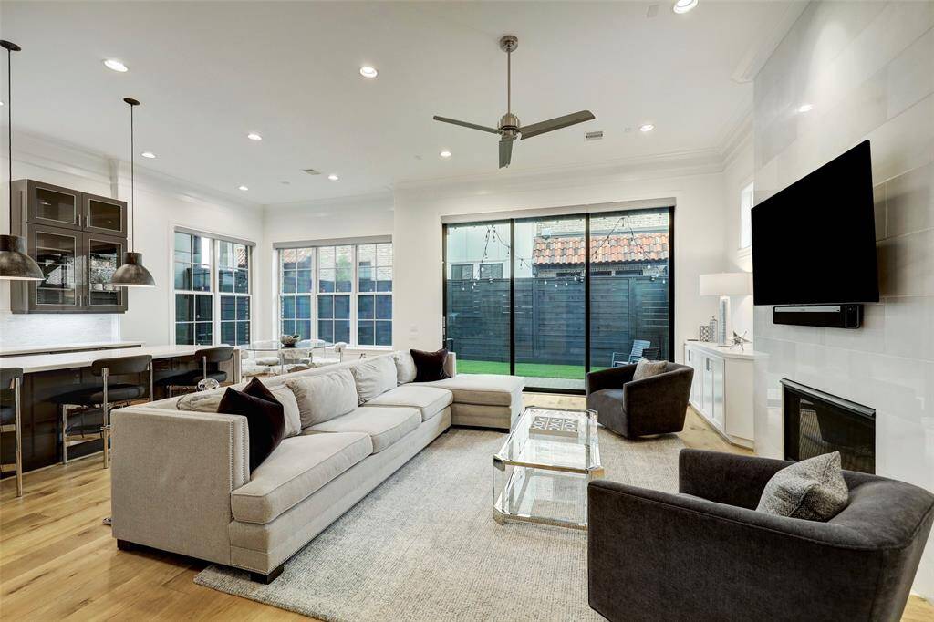 Open concept living room with beautiful 12' tall stacking glass panels allowing to expand your living area leading to the yard space, perfect for entertaining.