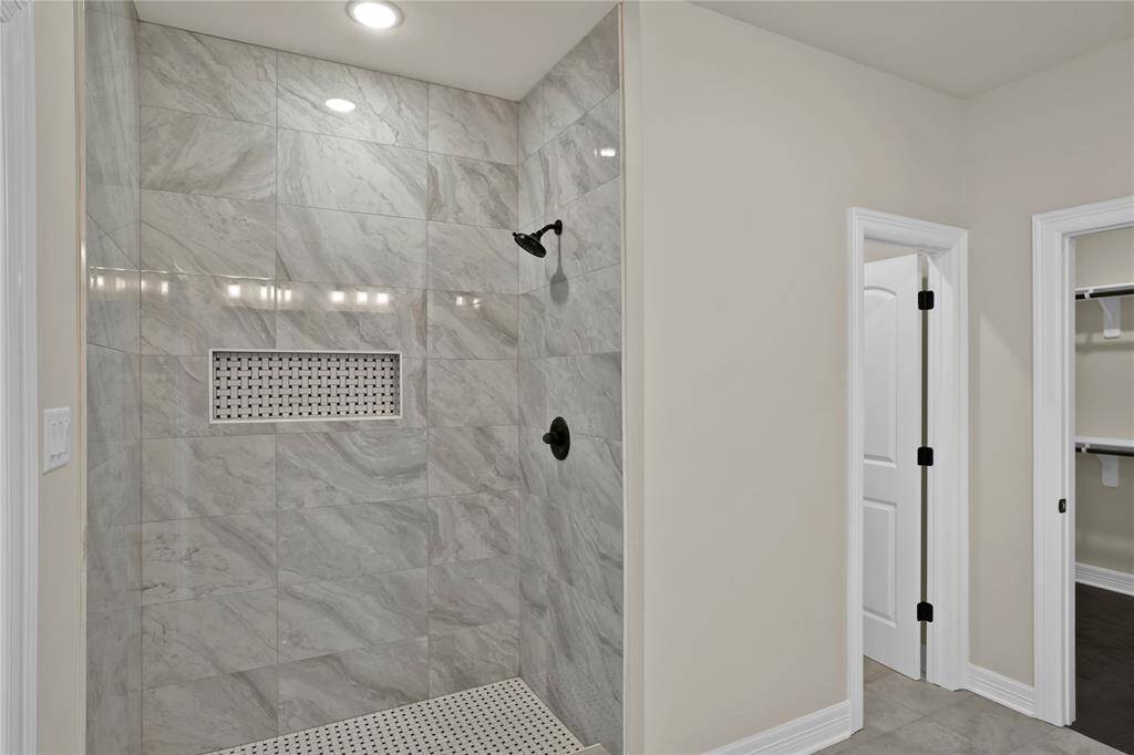 Luxurious en-suite bath with direct access to one of your two spacious primary walk-in closets