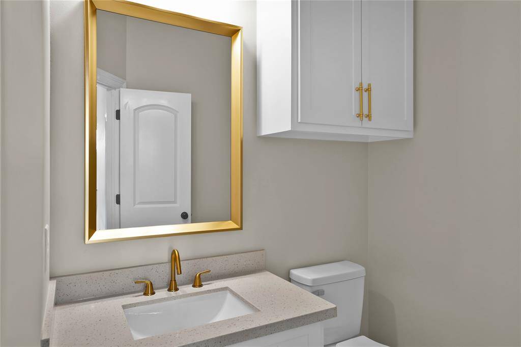 Stylish downstairs half bath conveniently located with elegant fixtures and ample storage