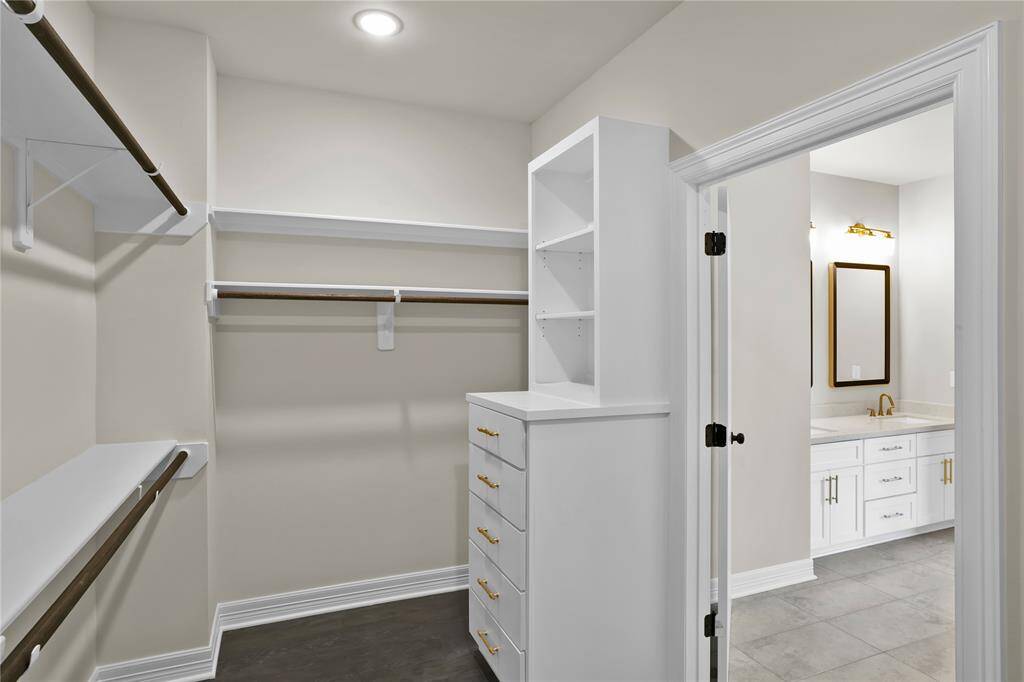Indulge in this large primary bedroom with a spacious walk-in closet featuring elegant built-in cabinetry and an extra closet for ample storage.