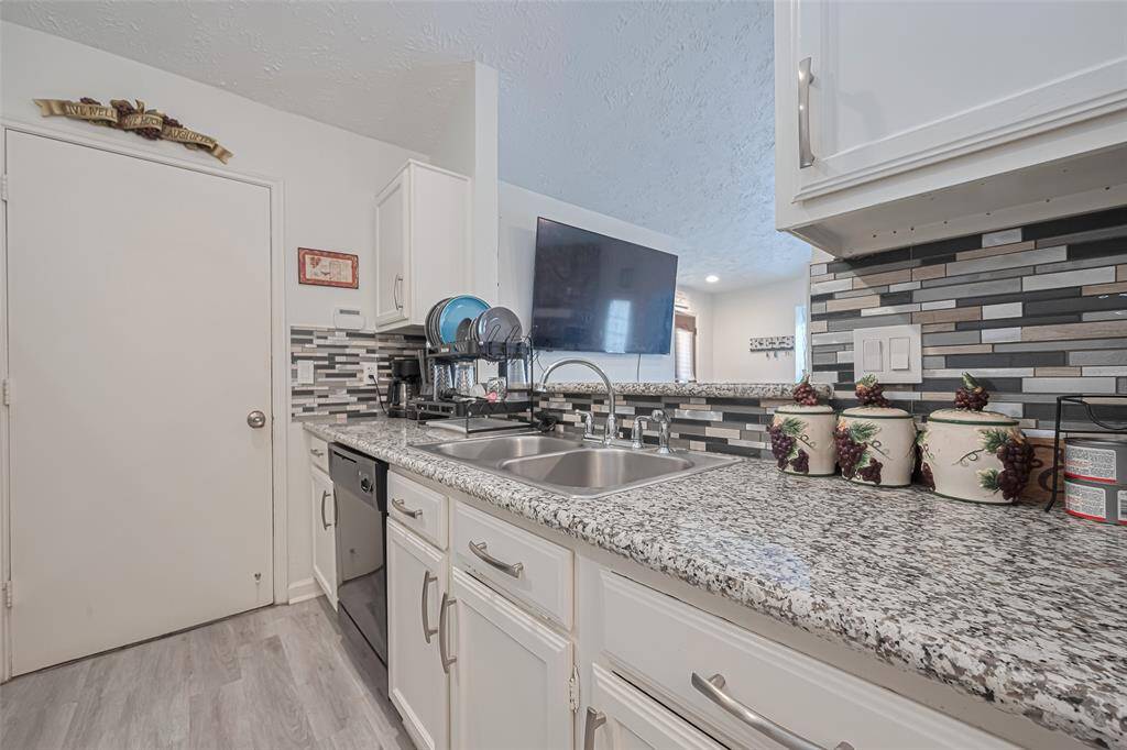 Kitchen featuring updated cabinets, backsplash, hardware & fixtures.  Also large opening from kitchen to breakfast bar area