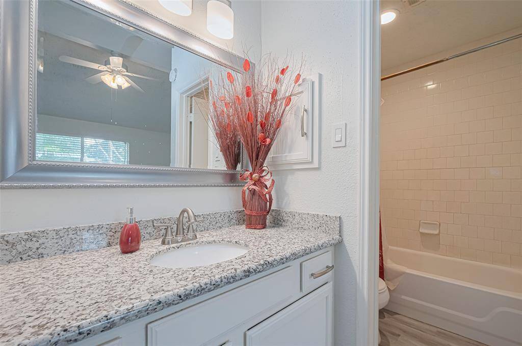 Granite covered vanity with undermount sink and expansive mirror.  All updated fixtures and hardware as well.This primary has combination tub/shower.
