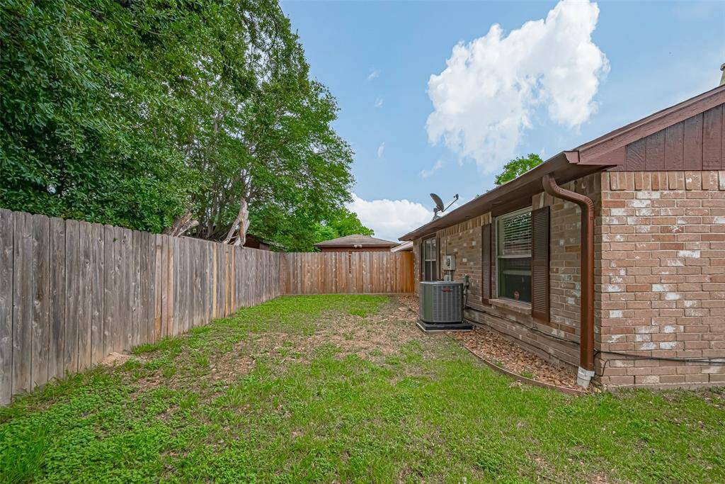 View of back of home with A/C unit and pebbles to keep water away from foundation