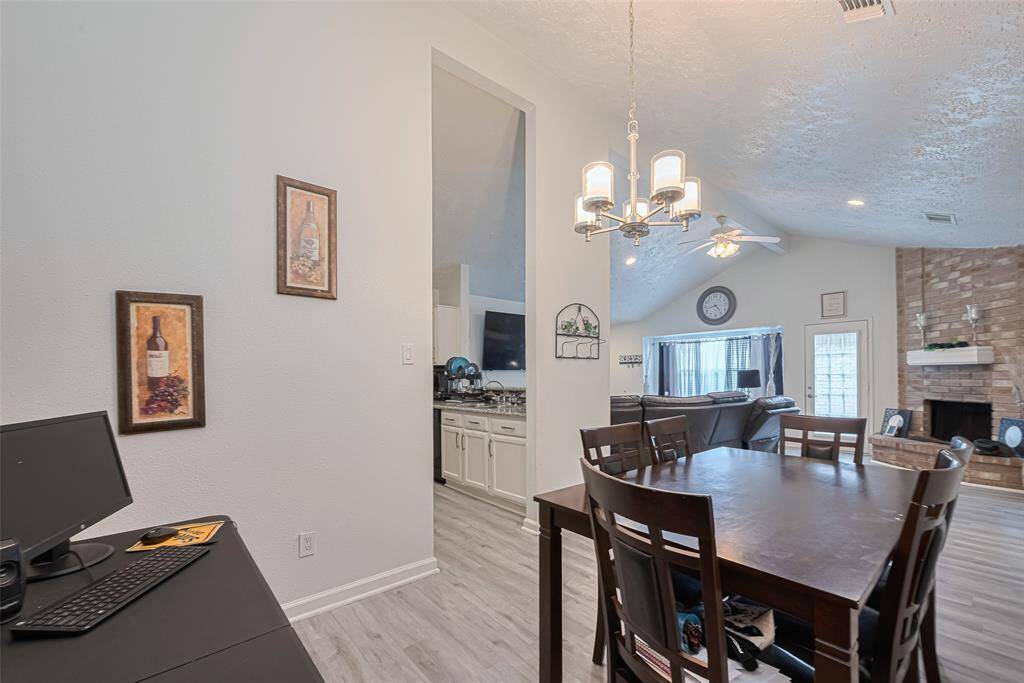 From back wall of dining area toward side and front of home offering a glimpse of the kitchen, dining room, and living area.