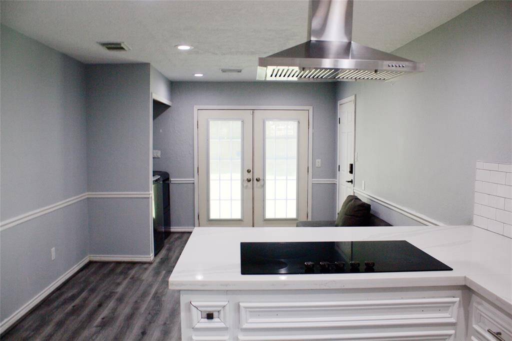 Modern quartz countertops and a sleek vent hood enhance this home's seamless flow.