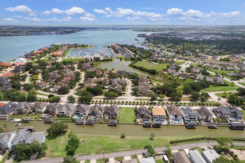 Luxurious waterfront living awaits with shopping and dining nearby. A glimpse of marina.