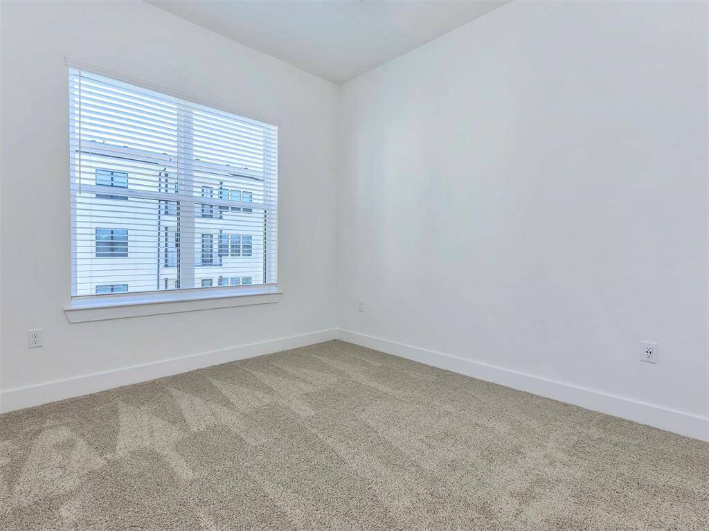 Second bedroom with walk-in closet, large window, and natural light